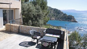 A balcony with a table and chairs overlooking a coastal view. - Residential flat (Ensuès-La-Redonne)