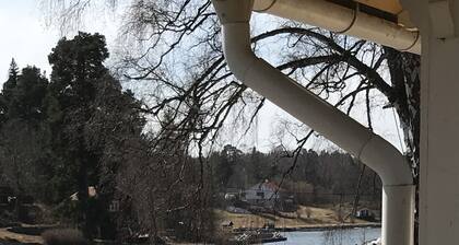 Cottage mit sonnigem Holzdeck am Wasser.