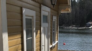 Une maison en bois avec un porche, une fenêtre et une porte.