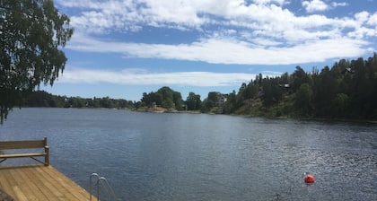 Cottage mit sonnigem Holzdeck am Wasser.