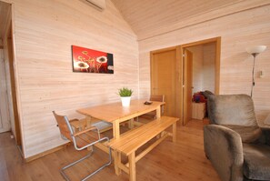 Un interior de madera con una mesa de comedor, un banco y una sola silla.