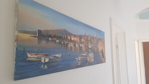 A painting of a harbor scene with boats and buildings.