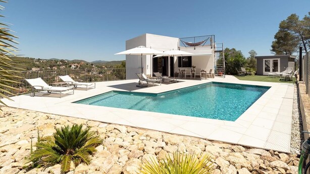 Une villa moderne dotée d’une piscine, d’un espace extérieur aménagé et offrant une vue sur le paysage environnant.