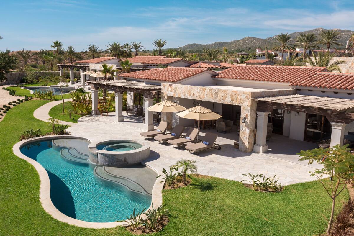 Un complexe hôtelier doté d’une piscine, d’un espace extérieur aménagé et offrant une vue sur un paysage montagneux.