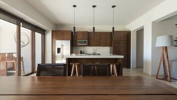 Una cocina moderna con una isla central, luces colgantes y armarios de madera.