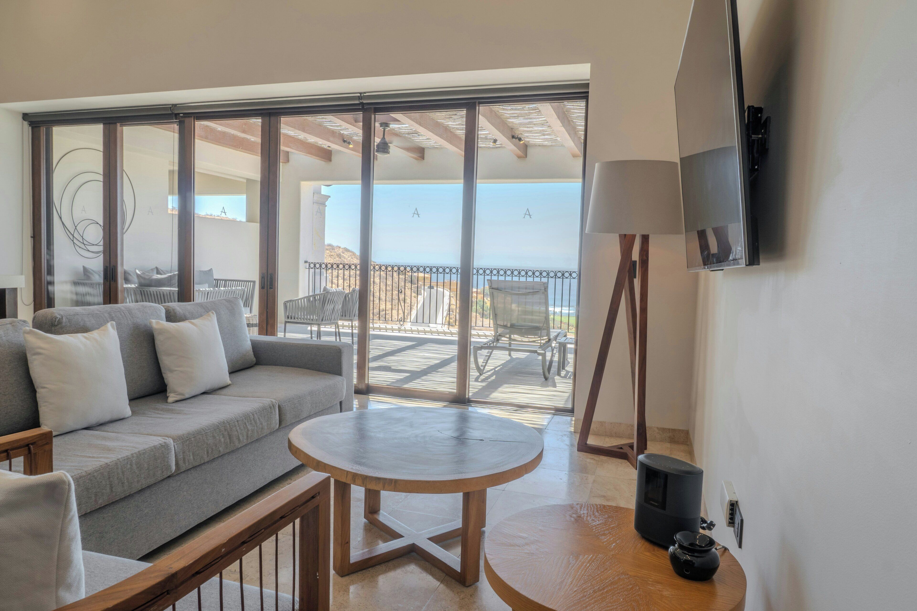 A balcony with a sofa, chairs, and a table.