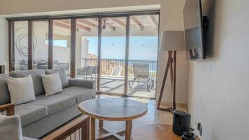 A balcony with a sofa, chairs, and a table.