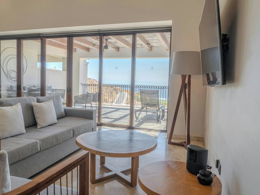 A balcony with a sofa, chairs, and a table.