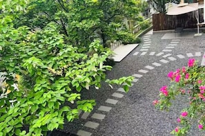 A garden pathway with stepping stones leading to a seating area. - Sha.heyue. Hotel (Emeishan City)