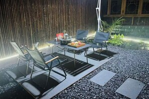 An outdoor seating area with a table, chairs, and a fruit bowl. - Sha.heyue. Hotel (Emeishan City)