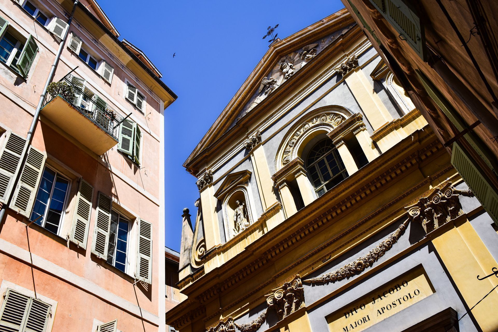 Ein Gebäude mit klassischer Architektur, das aufwendige Verzierungen und eine Statue zeigt.