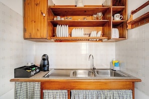 Una cocina con armarios de madera, un fregadero y una cafetera.