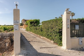 Un camino pavimentado que conduce a una propiedad con un letrero que indica '348/ATRI/TERINTZ'.