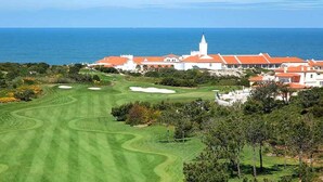 A golf course with a view of the ocean and a large white building with red roofs. - Luxury 4 bedroom villa with private pool on 5* golf & beach resort (Obidos)