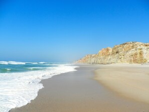 A beach with a sandy shore and a rocky cliff. - Luxury 4 bedroom villa with private pool on 5* golf & beach resort (Obidos)