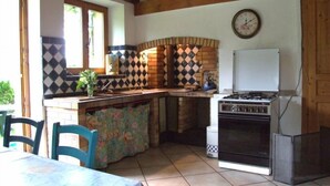 Une cuisine équipée d’une cuisinière à gaz, d’un évier et d’une fenêtre.