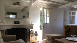 A living room with a fireplace, a sofa, a coffee table, and a bookshelf. - House / Villa - Cargese (Cargèse)