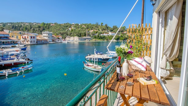 Ein Balkon mit Blick auf einen Yachthafen, Boote und eine Stadt im Hintergrund.
