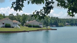 A lakeside property with two white houses, each featuring a porch and a small deck. - Fairfield Plantation Resort (Villa Rica)