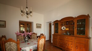Une salle à manger avec un buffet en bois, une nappe à motifs floraux et des chaises.