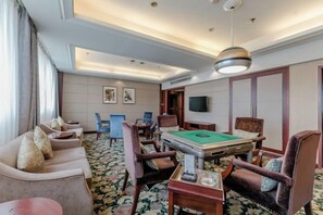 A hotel room with a pool table, comfortable seating, a flat-screen TV, and a large window. - Qingshen Hotel (Qingshen)