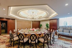 A hotel dining room with a round table, chairs, a chandelier, and a sofa. - Qingshen Hotel (Qingshen)