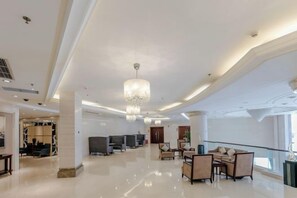 A spacious lobby with a high ceiling, chandeliers, and a seating area with sofas and chairs. - Qingshen Hotel (Qingshen)