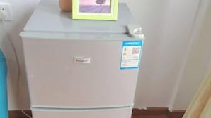 Ein weißer Kühlschrank mit einem 'Rongsan'-Etikett und einem QR-Code-Aufkleber.