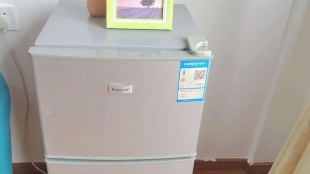A white refrigerator with a 'Rongsan' label and a QR code sticker. - Langfei Business Hotel (Chongqing)