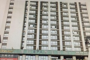 A multi-story building with a green sign indicating a hotel and a wellness center. - Langfei Business Hotel (Chongqing)