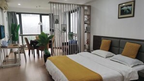 Ein modernes Hotelzimmer mit einem großen Bett, einem Schreibtisch und einem Balkon.