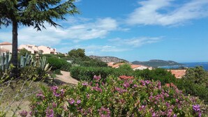 A coastal landscape with buildings, a clear sky, and a view of the sea.