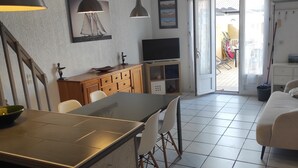 Eine moderne Küche mit Essbereich, einer Couch und einem Fernseher.