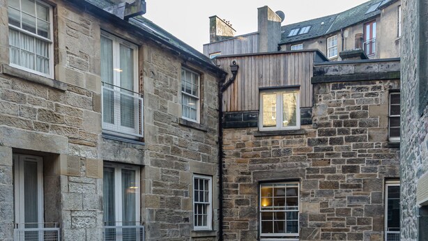 A stone building with multiple windows and doors, featuring a courtyard with stone paving. - Gorgeous Grassmarket Apartment! In quiet & secure courtyard in central Old Town (Edinburgh)