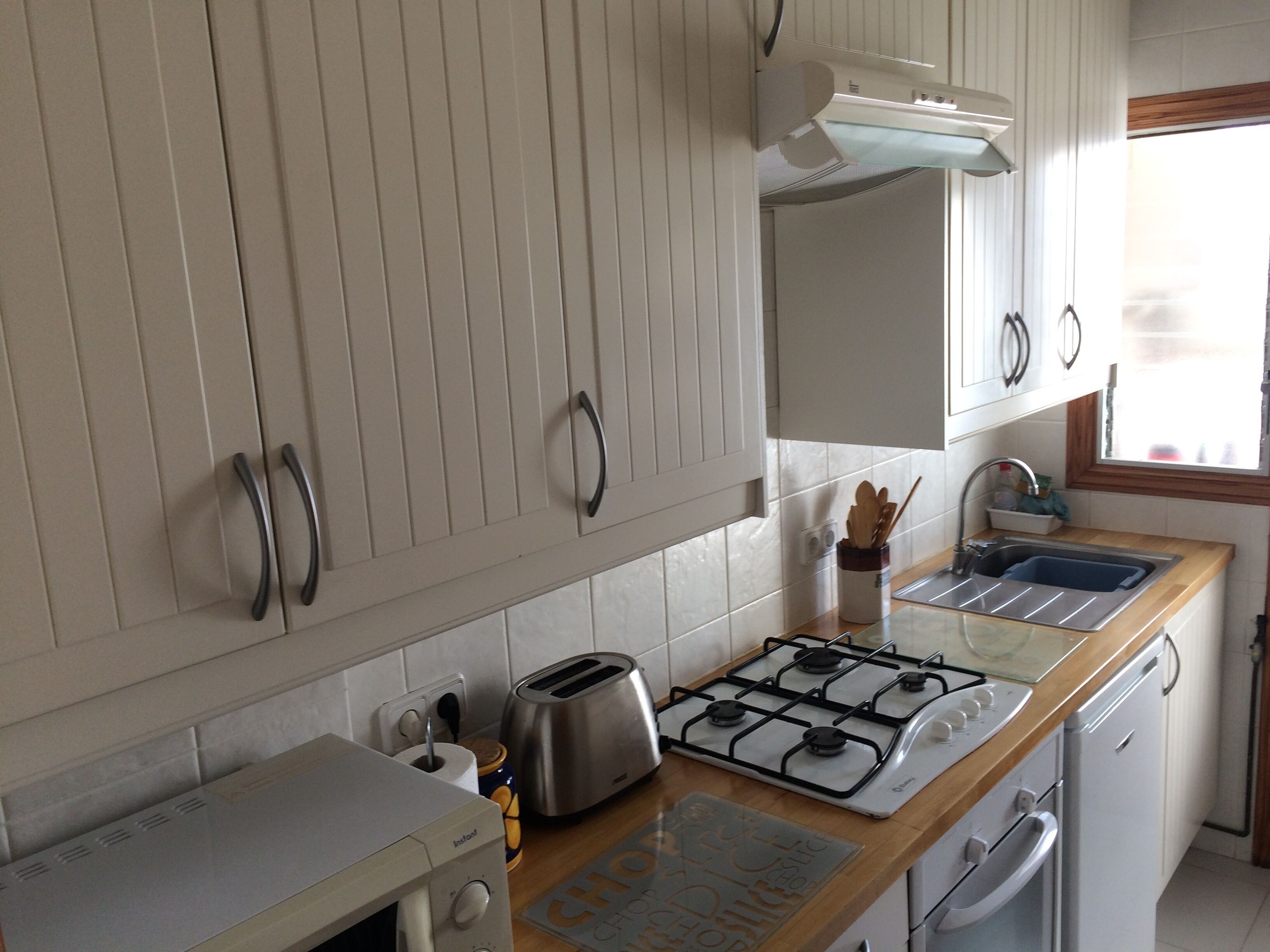 Kitchen showing microwave, toaster, oven, hob, fridge, sink