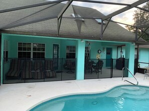 A covered outdoor area with a pool, seating, and a staircase leading to an upper level. - Our Home from Home Villa  Maximum occupancy is 8 people (Davenport)