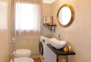 Kombination af bruser/badekar, hårtørrer, bidet, håndklæder