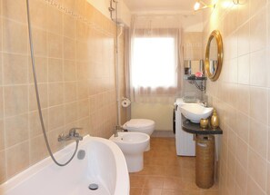 Kombination af bruser/badekar, hårtørrer, bidet, håndklæder