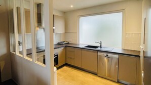 A modern kitchen with stainless steel appliances, a large window, and a wooden floor. - BZ sea view and close to town center (Roscoff)