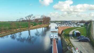 Un canal con barcos, un puente y un estacionamiento con automóviles.