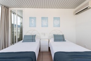 A hotel room with two beds, a sliding glass door, and three wall-mounted artwork pieces. - AirCon Penthouse Sea Views · Parking Pool · CENTER II 113 (Salou)