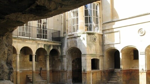 A courtyard with a pool, stone arches, and a balcony with a railing. - Hinton Lodge - Quaint Victorian four star cottage in a quiet rural location. (Trowbridge)