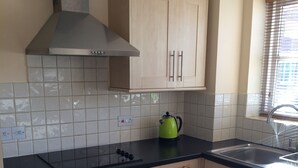 A kitchen with a stove, oven, and a kettle on the countertop. - Beautiful Kingston apartment (Kingston upon Thames)