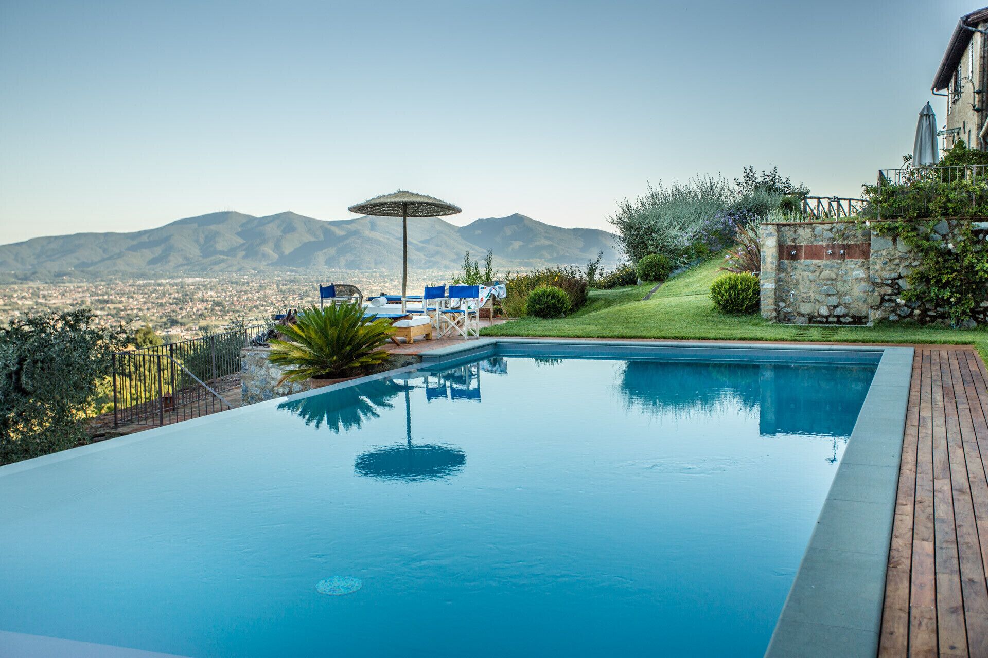 Une piscine offrant une vue sur les montagnes et le paysage urbain.