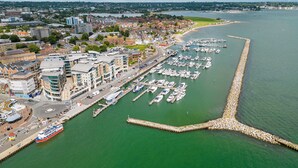 A marina with boats, a pier, and buildings in the background. - Panorama - 180-Degree Harbour Views (Poole)