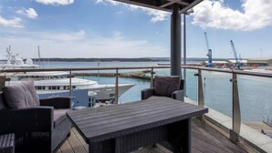 A covered outdoor deck with wicker furniture, overlooking a marina with boats and cranes. - Panorama - 180-Degree Harbour Views (Poole)