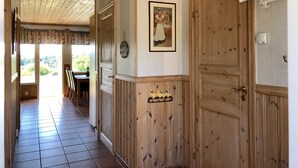 Um corredor com portas de madeira, um quadro emoldurado e um candeeiro no teto.
