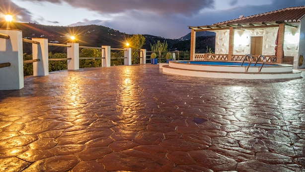 Un espace piscine aménagé sur le toit, avec un sol en pierre, une piscine et une structure en forme de pergola.