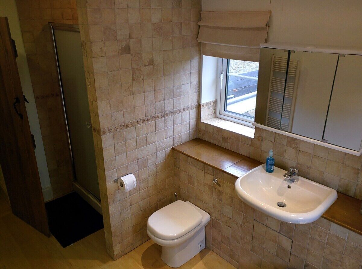 A bathroom with a toilet, sink, and shower.