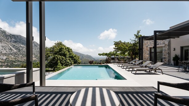 A pool area with lounge chairs and a view of mountains. - Eumelia Iconic Villa, with Heated Pool & Whirlpool, BBQ, Close to amenities (Rethymno)